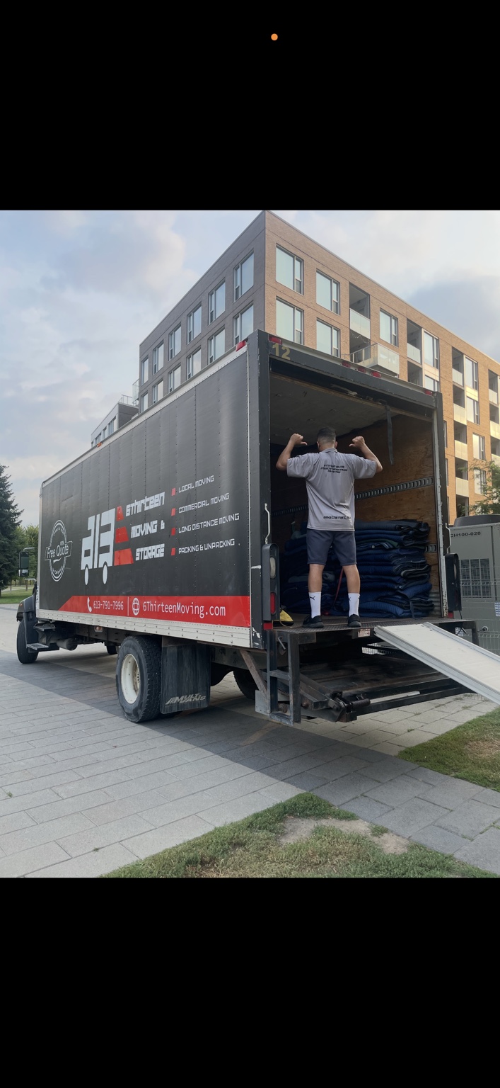 6Thirteen mover beside folded moving blankets inside a truck outside an apartment building