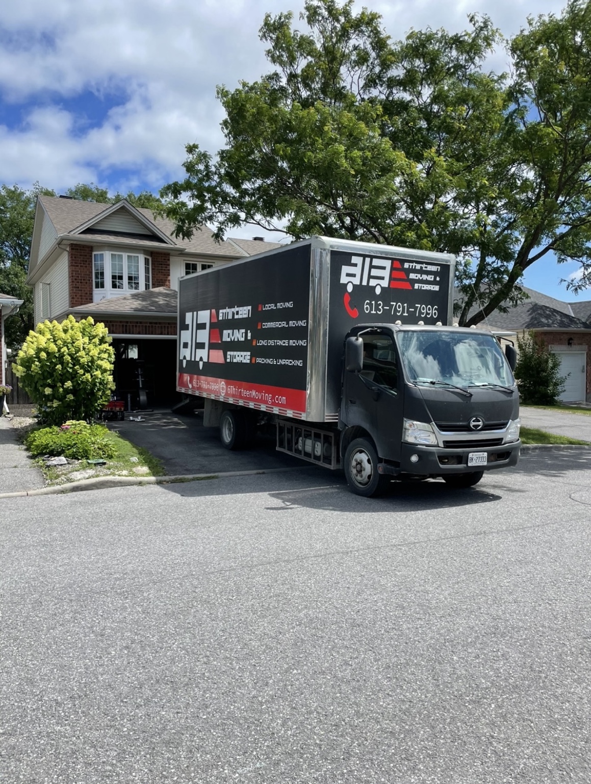 6Thirteen Moving & Storage truck outside a house on a sunny moving day